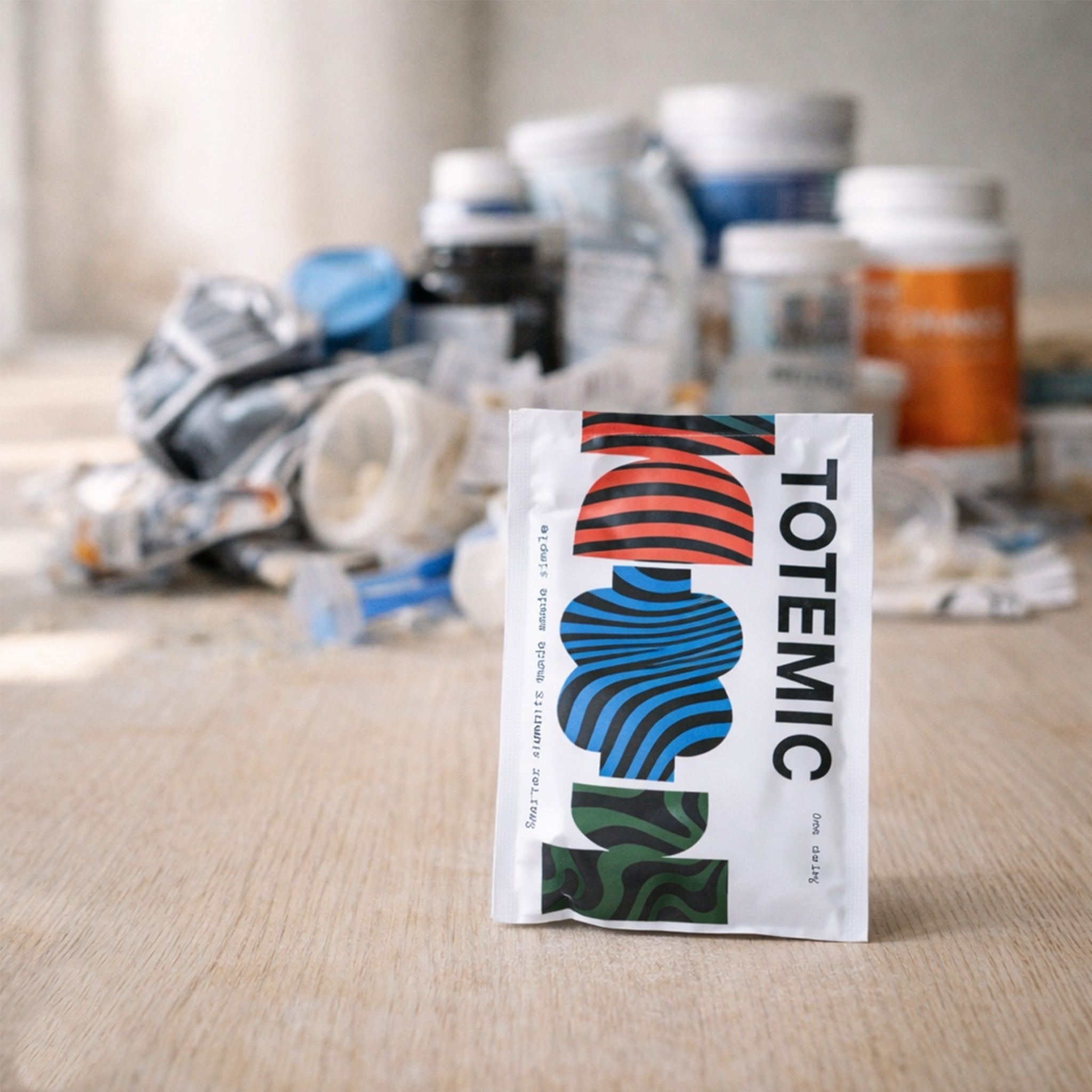Compostable TOTEMIC sachet in front of pile of used plastic